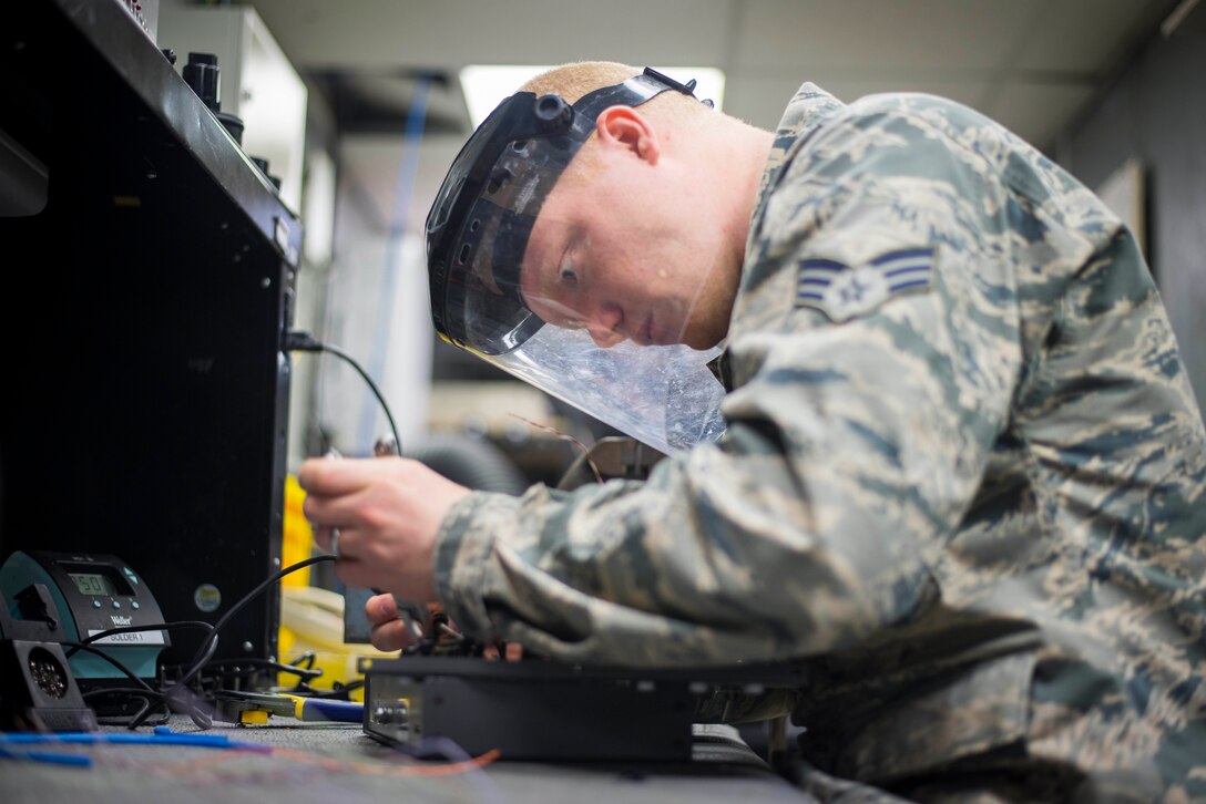 Senior Airman Michael Murphy, 744th Communications Squadron radio frequency transmissions technician, solders wires on a test panel box at Joint Base Andrews, Md., March 17, 2016. RF transmission technicians deploy, sustain, troubleshoot and repair the vast variety of communications devices to include antenna systems, tuners and transmission lines. (U.S. Air Force by Staff Sgt. Chad C. Strohmeyer/Released)