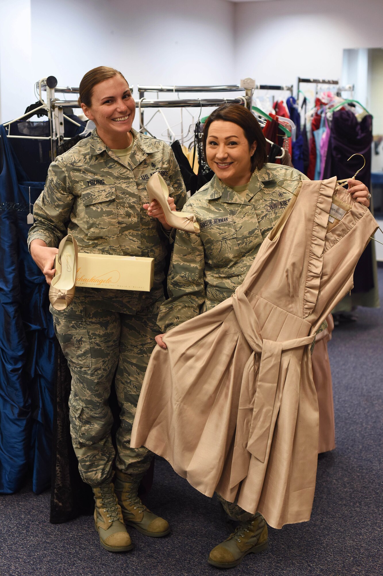 Staff Sgt. Sheena Young, 341st Missile Wing command chief executive, left, and Tech. Sgt. Jenny Johnson-Newman, 341st Medical Operations Squadron NCO in charge of health management, pose for a photograph at the Cinderella’s Closet shop March 15, 2016 at Malmstrom Air Force Base, Mont. The closet’s initiative is to help military members and dependents save money while having easy access to women’s dresses and gowns for formal and non-formal events. (U.S. Air Force photo/Airman Collin Schmidt) 