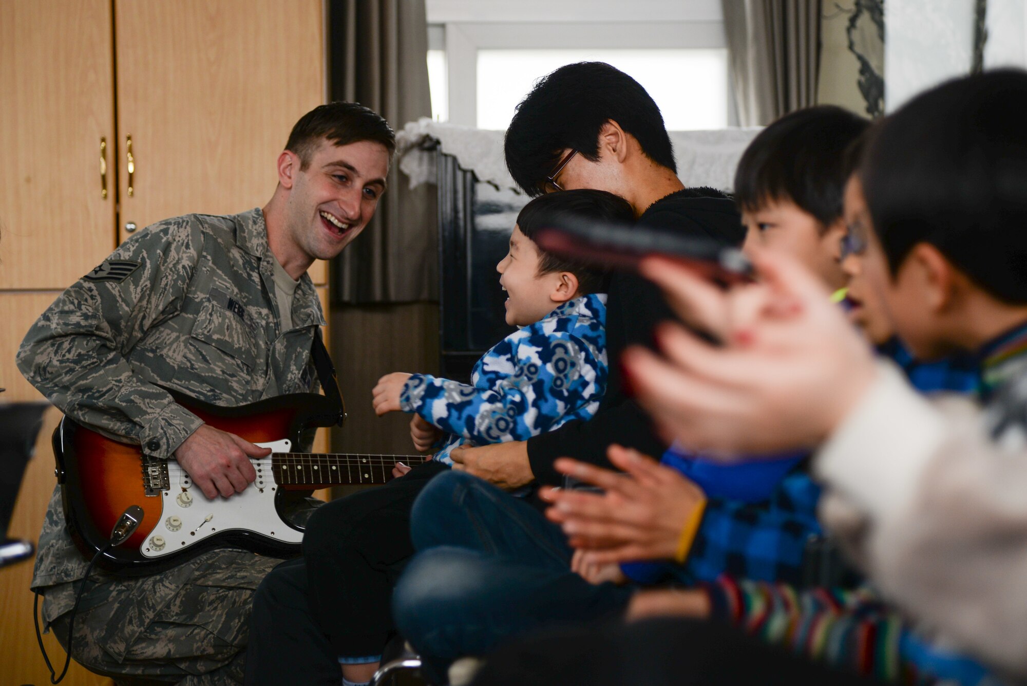 Staff Sgt. Aaron Weibe, Pacific Air Force regional band guitarist, performs for Korean children and families with the U.S. Air Force Band of the Pacific-Asia ensemble Pacific Trends March 13, 2016, in Pyeongtaek, Republic of Korea. The PACAF Band consists of full-time active duty musicians performing in the Western Pacific region in support of military and community relations objectives. (U.S. Air Force photo by Airman 1st Class Dillian Bamman/Released)
