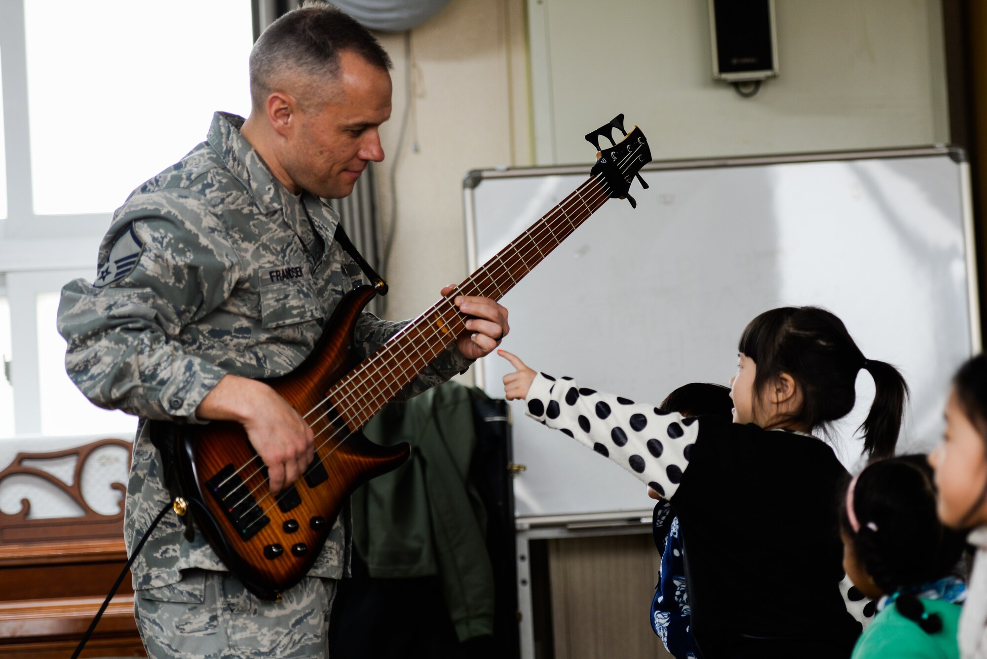 Master Sgt. Mark Frandsen, Pacific Air Force regional band bass guitarist, performs for Korean children and families with the U.S. Air Force Band of the Pacific-Asia ensemble Pacific Trends March 13, 2016, in Pyeongtaek, Republic of Korea. The PACAF Band consists of full-time active duty musicians performing in the Western Pacific region in support of military and community relations objectives. (U.S. Air Force photo by Airman 1st Class Dillian Bamman/Released)