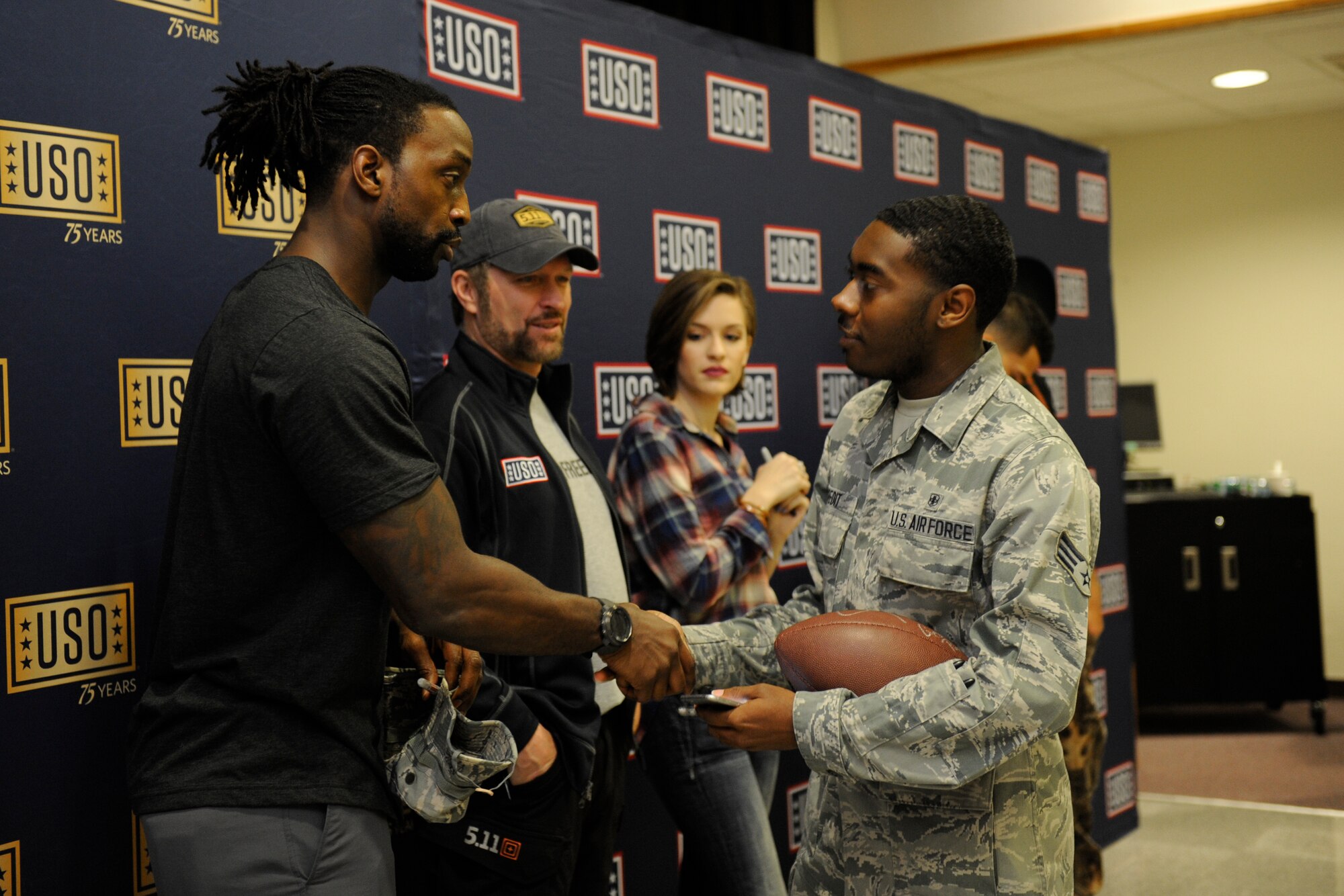 Carolina Panthers cornerback Charles Tillman greets U.S. Air Force Senior Airman Justin Credit, 18th Aerospace Medicine Squadron bioenvironmental engineering technician, during the United Service Organization Spring Visit tour, March 14, 2016, at Kadena Air Base, Japan. Tillman and other celebrity visitors signed autographs and took group photos with Team Kadena members as part of the USO's 75th anniversary celebration tour. (U.S. Air Force photo by Senior Airman Peter Reft)