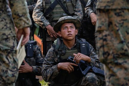 A Guatemalan Marine listens to U.S. Marine instructors explain proper firing range safety procedures March 10, 2016, Guatemala, prior to a live-fire exercise. The Guatemalan marines took part in a four week training course to hone their skills in basic infantry movements and urban operations with the intent of helping them combat drug trafficking organizations. (U.S. Air Force photo by Staff Sgt. Westin Warburton/RELEASED)