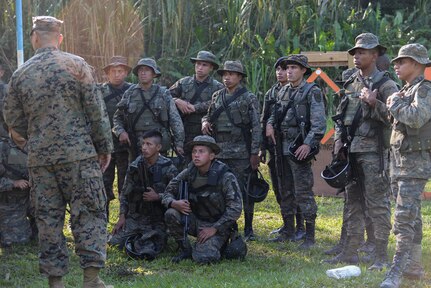 U.S. Marine Staff Sgt. Jorge Avila, instructor, translates directions to Guatemalan marines on proper shooting-range safety March 10, 2016, Guatemala, prior to a live fire skills test. The Guatemalan marines completed a final firing-range assessment before graduating a four week training course in which Marine trainers from a U.S. Marine Security Cooperation Team taught basic infantry maneuvers and how to conduct squad-level movements in an urban environment. (U.S. Air Force photo by Staff Sgt. Westin Warburton/RELEASED)
