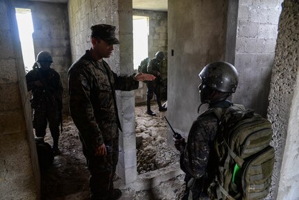 U.S. Marine Staff Sgt. Jorge Avila, instructor, gives directions to a Guatemalan Marine during a training exercise March 9, 2016, Guatemala. The Guatemalan marines partnered with trainers from a U.S. Marine Security Cooperation Team to learn basic infantry maneuvers and how to conduct squad-level movements in an urban environment. (U.S. Air Force photo by Staff Sgt. Westin Warburton/RELEASED)