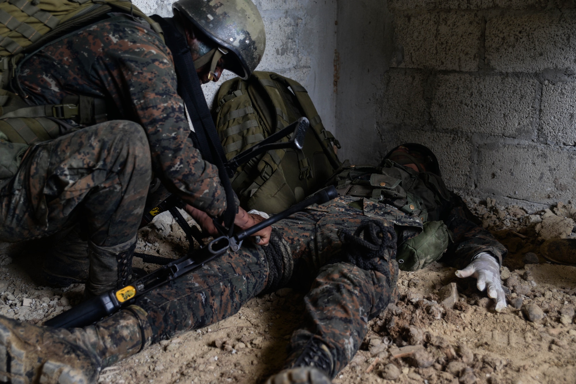 A Guatemalan Marine provides simulated care to his teammate March 9, 2016, Guatemala, during a final exercise of a four week training course. The course was requested by the Guatemalans to provide training and real-life simulations for their marines. (U.S. Air Force photo by Staff Sgt. Westin Warburton/RELEASED)