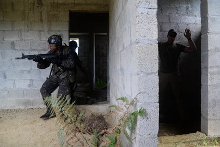 Guatemalan marines sweep a room during an exercise while a U.S. Marine instructor acts as an adversary March 9, 2016, Guatemala. The Guatemalan and U.S. Marines partnered in a four-week course to learn best practices for urban operations and countering drug trafficking organizations in the region. (U.S. Air Force photo by Staff Sgt. Westin Warburton/RELEASED)
