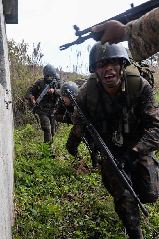 Guatemalan marines enter a house used as an objective March 9, 2016, Guatemala, during the final exercise of a four-week training course. During the course, U.S. Marine trainers provided best practices for small unit movements and how to operate in urban environments against transnational drug trafficking organizations. (U.S. Air Force photo by Staff Sgt. Westin Warburton/RELEASED)