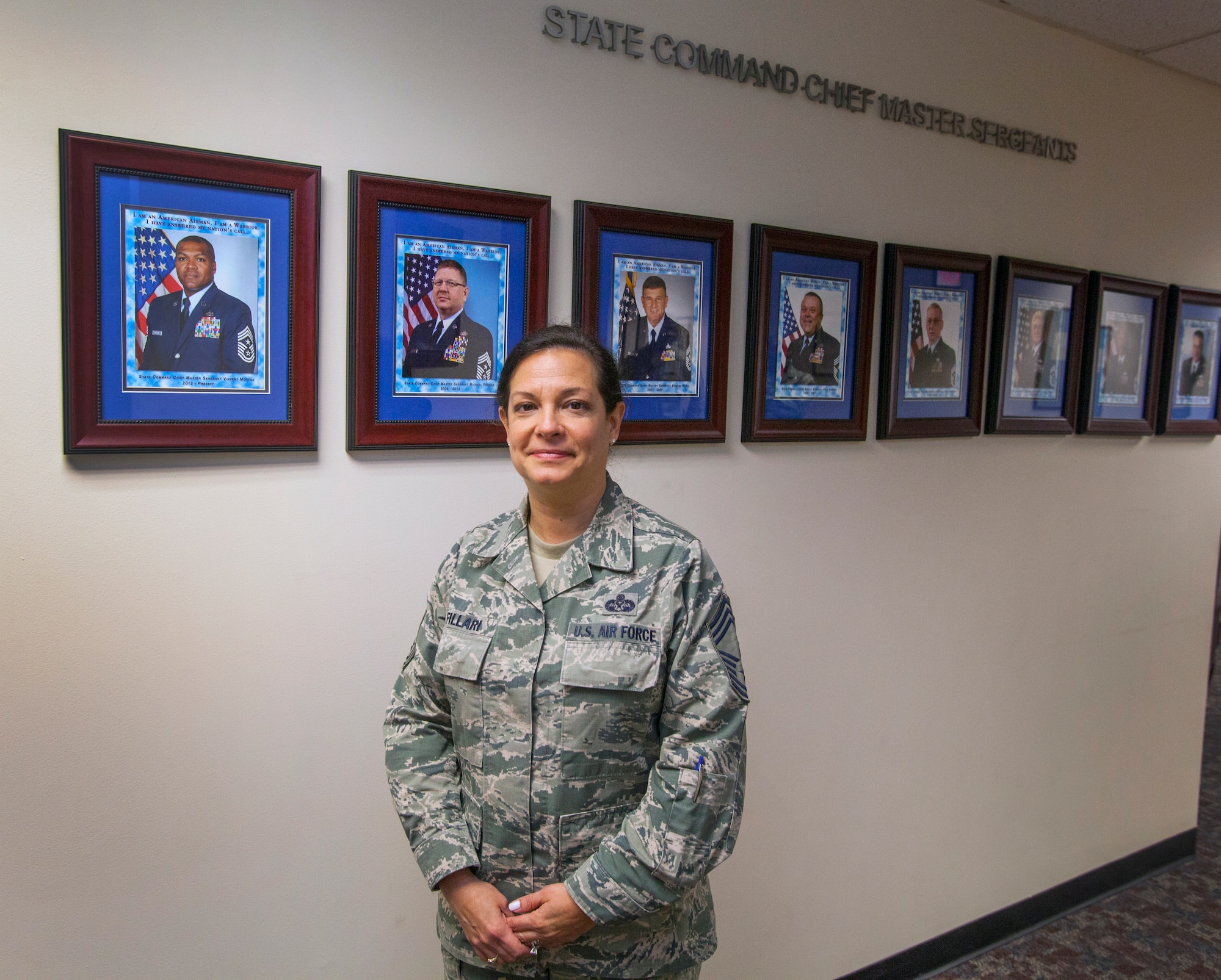 New Jersey State Command Chief Master Master Sgt. Janeen M. Fillari poses in front of the State Command Chief wall at Joint Force Headquarters, New Jersey Air National Guard, at Joint Base McGuire-Dix-Lakehurst, N.J., March 15, 2016. Fillari is the first woman to serve as the New Jersey State Command Chief Master Sergeant for the New Jersey Air National Guard. (U.S. Air National Guard photo by Master Sgt. Mark C. Olsen/Released)