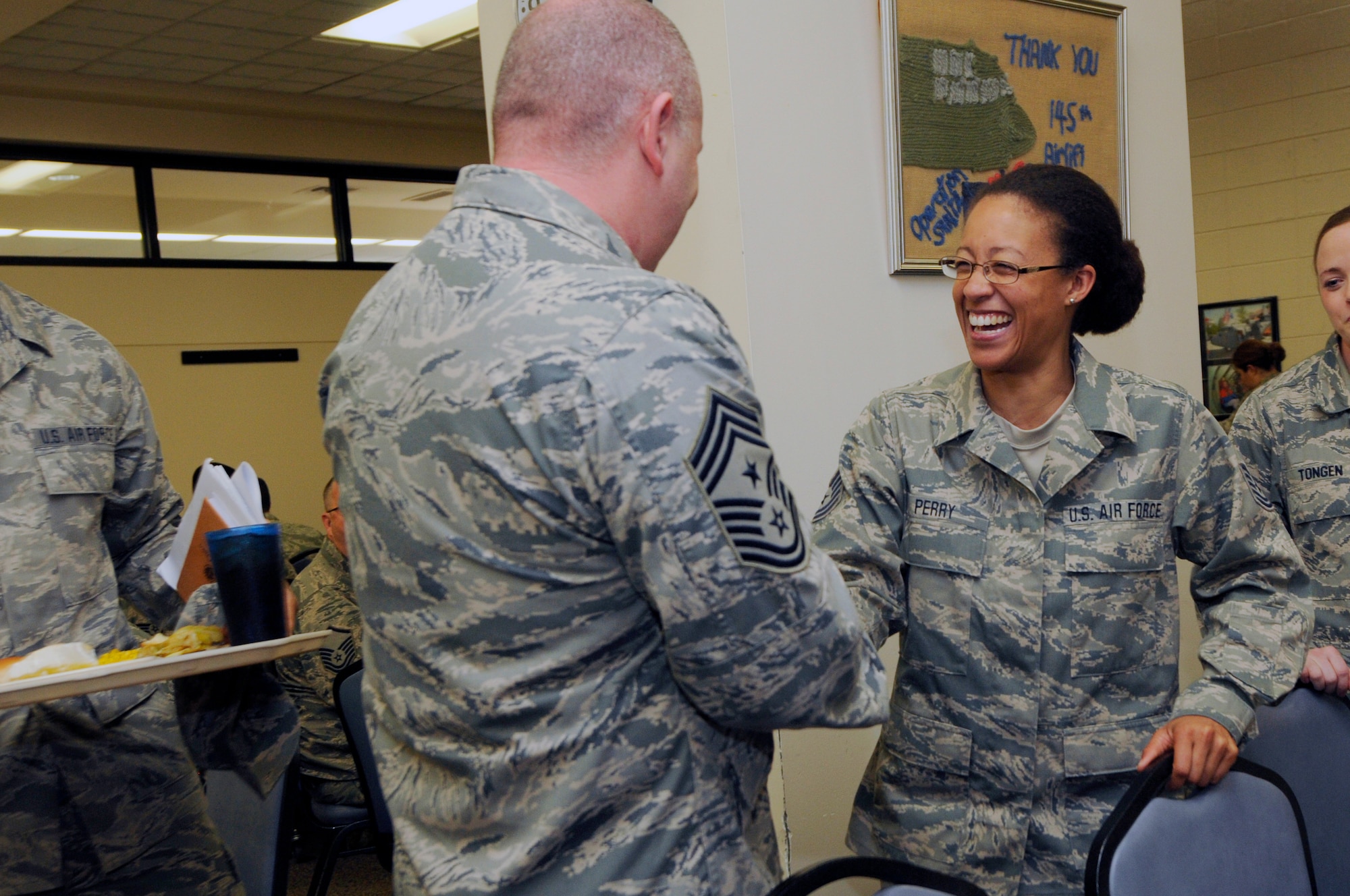 U.S. Air Force Tech. Sgt. Carissa Perry (right), 145th Communications Flight cyber systems operations, shakes hands with Command Chief Master Sergeant of the Air National Guard James W. Hotaling during a lunch with Airmen at the North Carolina Air National Guard Base, Charlotte Douglas International Airport, March 12, 2016. Hotaling gave advice on how to be successful, and talked about his focus on renewing the profession of arms. (U.S. Air National Guard photo by Staff Sgt. Julianne M. Showalter/Released)