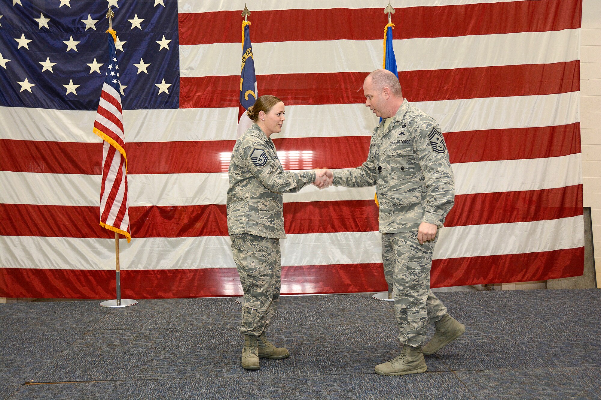 U.S. Air Force Master Sgt. Rebecca Tongen, 145th Airlift Wing (AW) installation emergency manager, receives a coin from Command Chief Master Sergeant of the Air National Guard James W. Hotaling during an enlisted “all call” held at the North Carolina Air National Guard Base, Charlotte Douglas International Airport, March 12, 2016. Tongen is the recipient of the NCANG 2015 Senior Non-Commissioned Officer of the Year Award. (U.S. Air National Guard photo by Senior Airman Laura J. Montgomery/Released)

