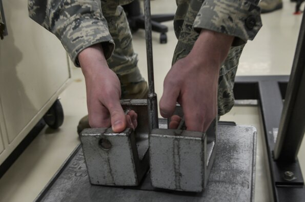 Staff Sgt. Micah Sheffield, 374th Maintenance Squadron Precision Measurement Equipment Laboratory physical dimensions NCO in charge, inspects a transducer to ensure it’s calibrated at Yokota Air Base, Japan, Feb. 22, 2016. The laboratory receives a variety of equipment to repair and inspect ranging from torque wrenches, spectrum analyzers, communication analyzers, avionics equipment and scales. (U.S. Air Force photo by Senior Airman David Owsianka/Released)