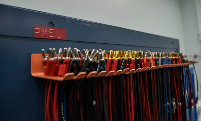 Pomona cables hang on a shelf within the 374th Maintenance Squadron Precision Measurement Equipment Laboratory shop at Yokota Air Base, Japan, Feb. 22, 2016. The cables are used to perform electrical and frequency tests on equipment. Yokota’s PMEL flight provides calibration support for about 4,000 pieces of equipment and 76 work centers, worth approximately $6.7 million. (U.S. Air Force photo by Senior Airman David Owsianka/Released)