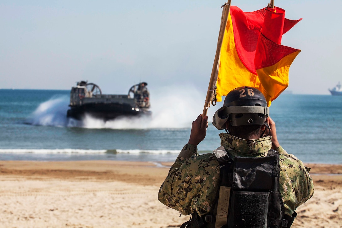 A sailor signals a hovercraft as it arrives on the beach as part of Ssang Yong 16 on Dogu Beach, South  Korea, March 12, 2016. Ssang Yong is a biennial combined amphibious exercise conducted by U.S. forces with the Republic of Korea Navy and Marine Corps, Australian Army and Royal New Zealand Army Forces in order to strengthen interoperability and working relationships across a wide range of military operations. Marine Corps photo by Gunnery Sgt. Ismael Pena
