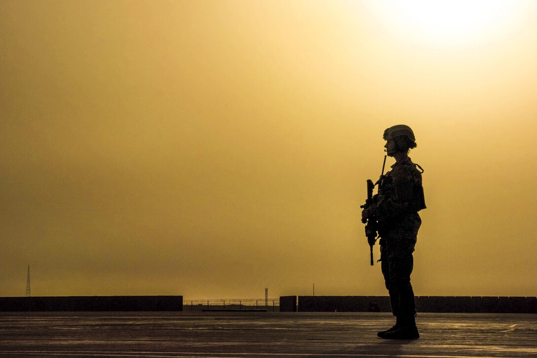 Air Force Airman 1st Class Alexandra Powell scans an airfield for potential threats while a C-130J Super Hercules aircraft transfers equipment and personnel on Camp Shorabak, Afghanistan, March 16, 2016. Powell is a security member assigned to the 455th Expeditionary Security Forces Squadron Fly Away Security Team. Air Force photo by Tech. Sgt. Robert Cloys