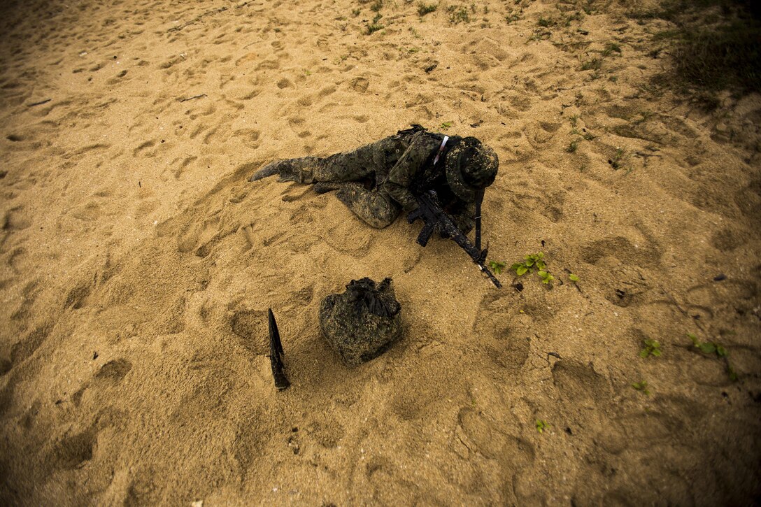 A Japan Ground Self-Defense Force member calls in the second wave of team members Mar. 11, at Kin Blue, Okinawa, Japan. The first reconnaissance team checked for simulated enemies and any other obstacles the rest of the teams could encounter.The JGSDF observed U.S. Marines with 3rd Reconnaissance Battalion, 3rd Marine Division, III Marine Expeditionary Force, conducting raid missions, amphibious training and scout swimmer classes. The JGSDF members are with the 43rd Infantry Regiment, 8th Division, Western Army. (U.S. Marine Corps photo by Cpl. Isaac Ibarra/Released)