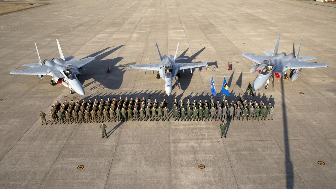 Members of Marine Fighter Attack Squadron 314 and Japan Air Self-Defense pose for a photo in front of an F/A-18A and two F-15s at Komatsu Air Base, Japan, during the Komatsu Aviation Training Relocation exercise March 17, 2016. VMFA-314, home based out of Marine Corps Air Station Miramar, San Diego, temporarily deployed to MCAS Iwakuni for a six month rotation with the unit deployment program, is forward deployed to Komatsu, Japan for the ATR. 