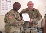 DLA Distribution Korea’s commander, Army Lt. Col. Mark Wolf presents Army Master. Sgt. Stephane Dia with a certificate during his promotion ceremony on Mar. 7.