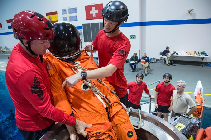 Master Sgt. Chris Seinkner, 308th Rescue Squadron, located at Patrick AFB, Fla., teams up with Tech. Sgt. Cameron Hystad, 88th Test and Evaluation Squadron, Nellis AFB, Nev., to exercise egressing a “NASA astronaut” through the docking hatch (top hatch) of the Orion Capsule under the guidance of the 45th Operations Group’s Detachment 3 during a recent exercise at NASA’s Neutral Buoyancy Lab in Houston, Texas. The Air Force and NASA work together to prepare for contingency landing site support, payload security, medical support, coordination of airlift/sealift for contingency operations, as well as other support services required in the event of a spacecraft emergency. Detachment 3 was chartered in 1959 by the Secretary of Defense as the DoD Mercury Support Office [later renamed DoD Manned Space Flight Support Office (DDMS)], its express purpose is providing DoD support to our nation's human space flight programs, putting people into space and returning them safely to Earth. (Courtesy photo/NASA)
