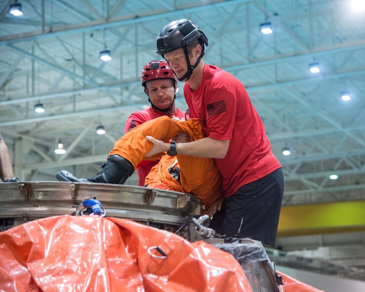 Master Sgt. Chris Seinkner, 308th Rescue Squadron, Patrick AFB, Fla. teams up with Tech. Sgt. Cameron Hystad and Staff Sgt. Eli Reynolds, 88th Test and Evaluation Squadron, Nellis AFB, Nev., to exercise egressing a “NASA astronaut” from the docking hatch of an Orion Capsule during a recent exercise at NASA’s Neutral Buoyancy Lab in Houston, Texas. Air Force Pararescue teams participated in an astronaut rescue and recovery exercise coordinated by Detachment 3 and NASA. The two agencies work together to prepare for contingency landing site support, payload security, medical support, coordination of airlift/sealift for contingency operations, as well as other support services required in the event of a spacecraft emergency. Detachment 3 was chartered in 1959 by the Secretary of Defense as the DoD Mercury Support Office [later renamed DoD Manned Space Flight Support Office (DDMS)], its express purpose is providing DoD support to our nation's human space flight programs, putting people into space and returning them safely to Earth. (Courtesy photo/NASA)
