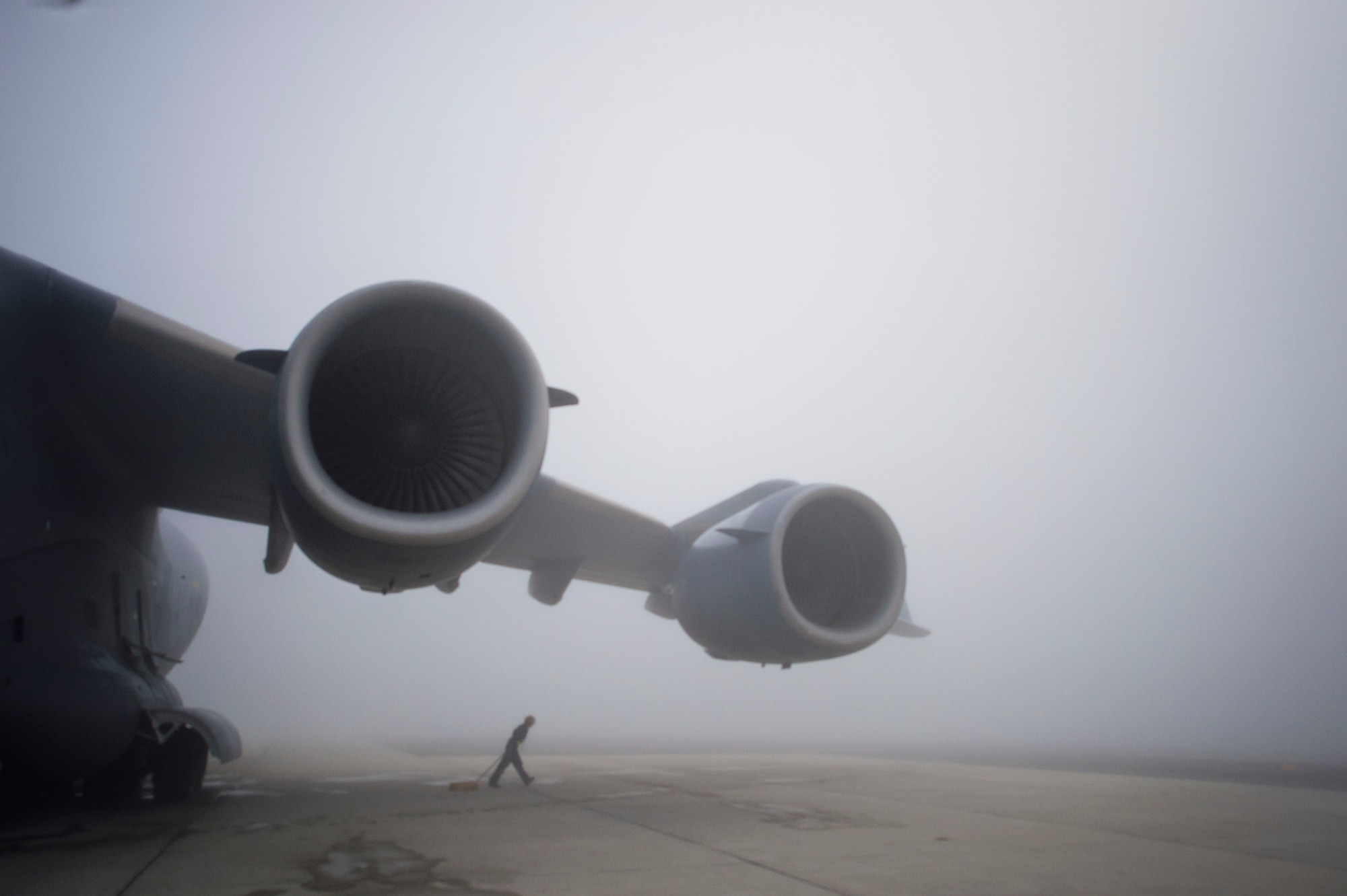 Amidst thick fog, Tech. Sgt. Christine King, 512th Airlift Wing, pulls the wheel chalk away from a C-17 Globemaster III aircraft prior to launching the mission from Dover Air Force Base, Del., March 17, 2016. As a dedicated crew chief, King frequently trains reserve and active-duty Airmen on C-17 maintenance and procedures. (U.S. Air Force photo/ Capt. Bernie Kale)
