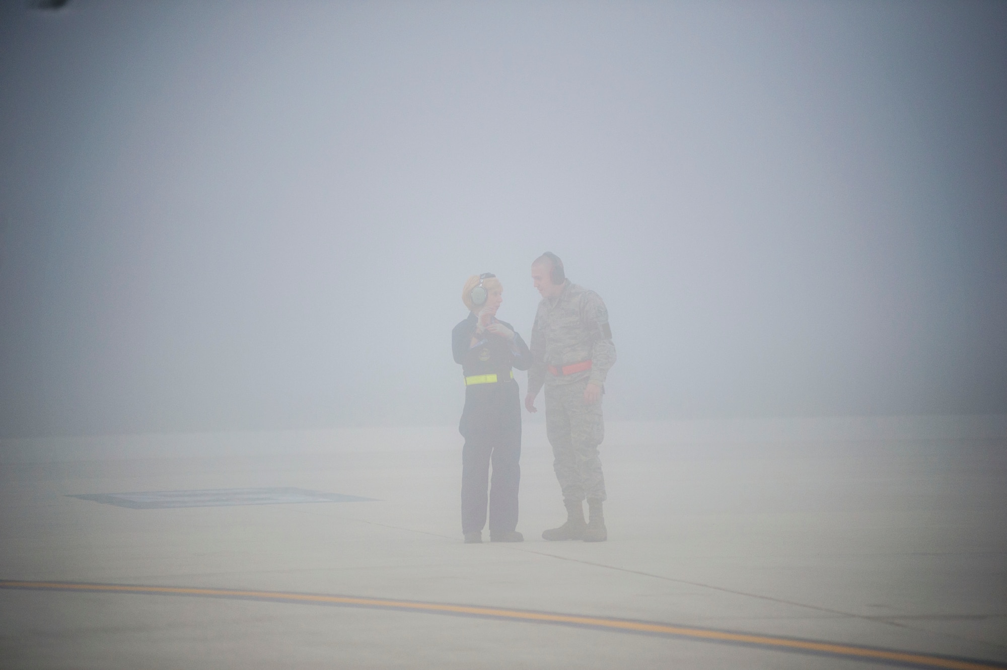 Tech. Sgt. Christine King (left), 512th Airlift Wing, explains to Airman 1st Class Anthony Mahon, 436th Airlift Wing, the procedures to marshalling an aircraft safely between other aircraft. As a dedicated crew chief, King frequently trains reserve and active-duty Airmen on C-17 maintenance and procedures, including aircraft marshalling. (U.S. Air Force photo/ Capt. Bernie Kale)