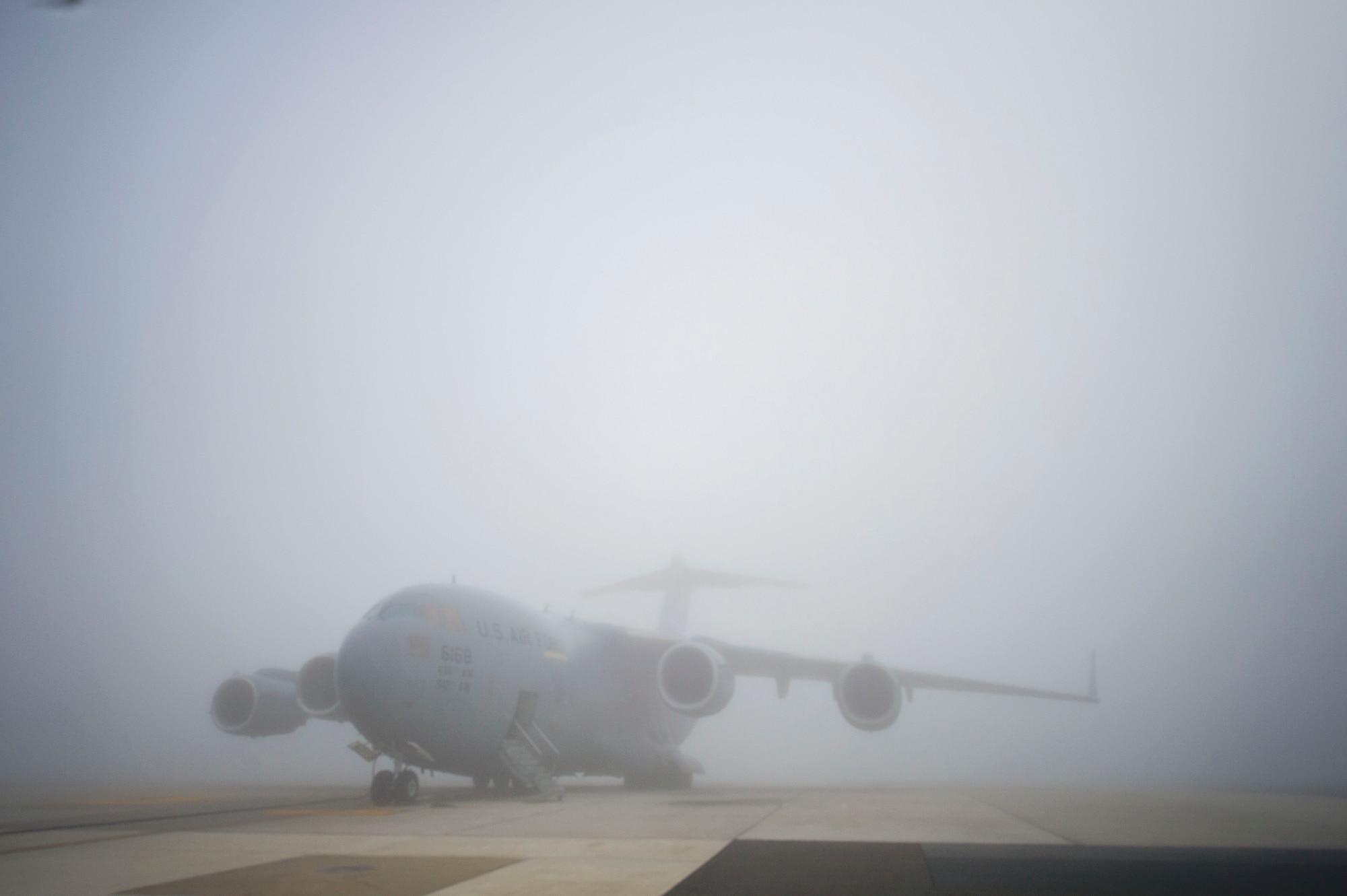 A Team Dover C-17 Globemaster III aircraft sits on the foggy runway waiting for the weather to clear before the mission launch at Dover Air Force Base, Del. The East Coast base is home to 13 C-17s, which provide rapid global mobility and global engagement. (U.S. Air Force photo/ Capt. Bernie Kale)