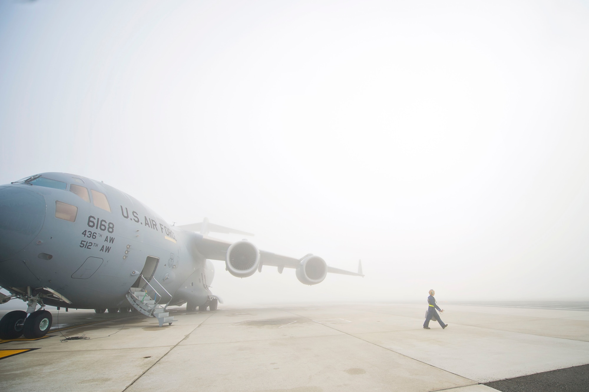 Tech. Sgt. Christing King, 512th Airlift Wing, walks through the fog away from her C-17 Globemaster III aircraft to get additional equipment needed to marshal the aircraft to the flightline on Dover Air Force Base, Del., March 17, 2016. King is a dedicated crew chief assigned to this specific aircraft and is knowledgeable in all maintenance areas of the jet. (U.S. Air Force photo/ Capt. Bernie Kale)
