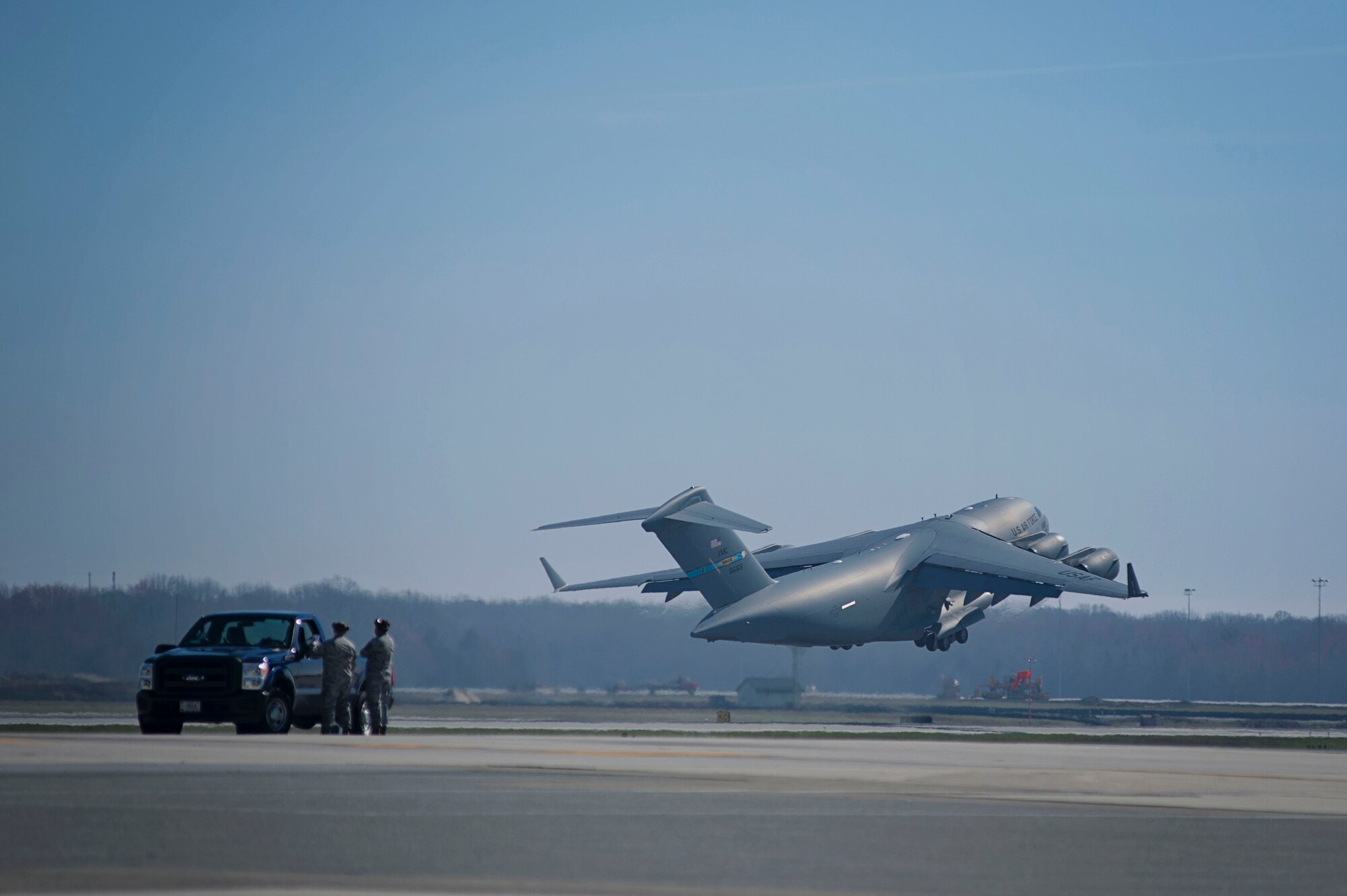 Team Dover maintenance personnel watch as a C-17 Globemaster III takes off from Dover Air Force Base, Del., March 17, 2016. Reservists and active duty Airmen work side-by-side daily in the maintenance and other career fields, promoting Total Force Integration within Team Dover. (U.S. Air Force photo/ Capt. Bernie Kale)