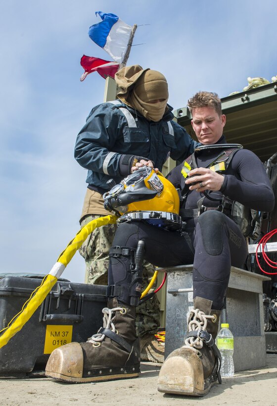 Navy Lt. Christopher Ferguson, right, sits as standby diver while fellow U.S. and South Korean divers work on constructing a simulated expeditionary wharf in the water during Foal Eagle 2016 at Chinhae, South Korea, March 10, 2016. Ferguson is a U.S. Navy Expeditionary Combat Command dive medical officer assigned to Navy underwater construction teams. Navy photo by Petty Officer 1st Class Charles E. White