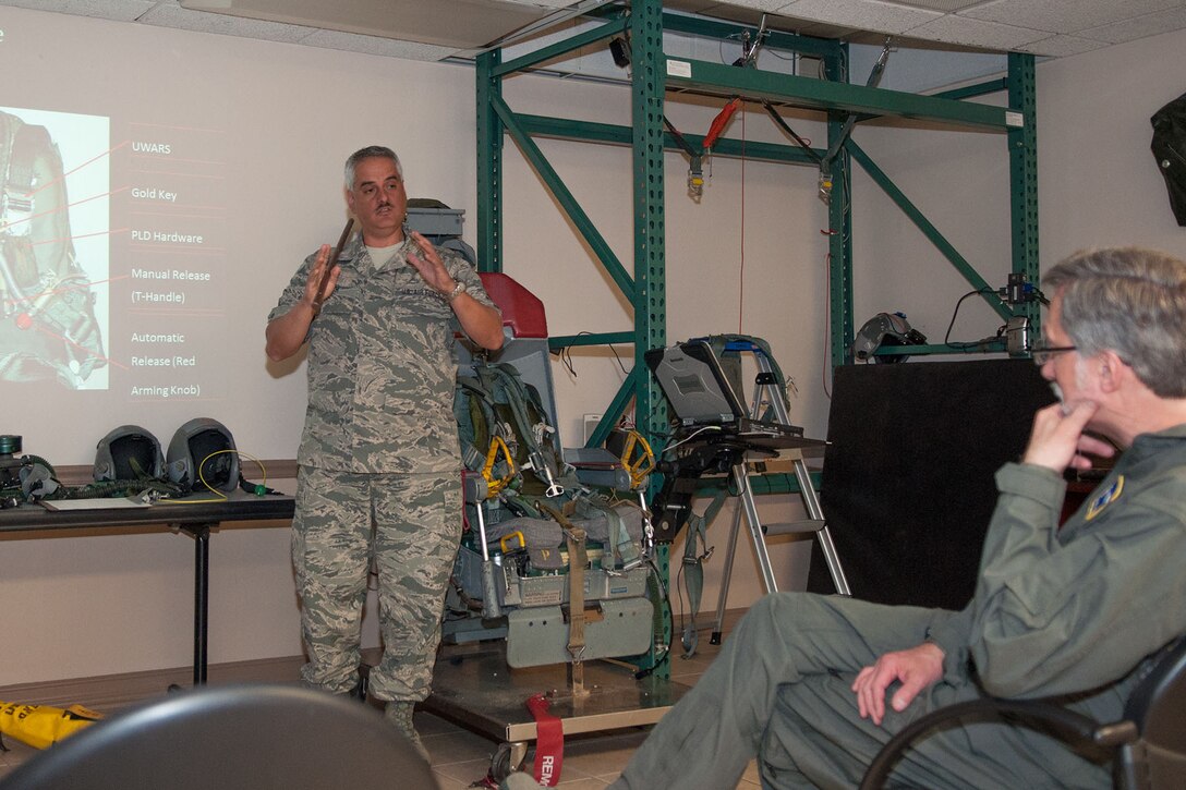 U.S. Air Force Master Sgt. Brad Schoth, assigned to the 307th Operation Support Squadron, explains emergency egress procedures out of the B-52 Stratofortress to the Director of Los Alamos National Laboratory, Charles McMillan, Barksdale Air Force Base, La. on March 14, 2016. McMillan received the opportunity to fly with the 93rd Bomb Squadron in a B-52 after working for over 10 years at Los Alamos initially in the weapons physics organization and then as director. (U.S. Air Force photo by Master Sgt. Dachelle Melville/Released)