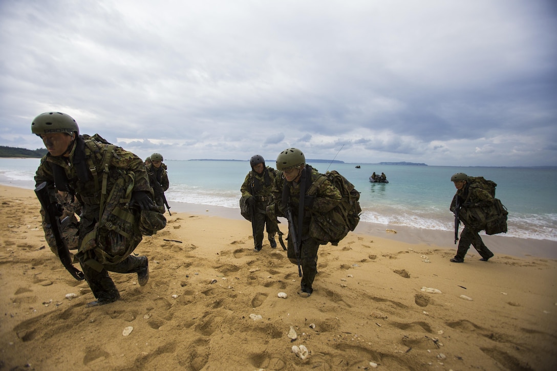 Japan Ground Self-Defense Force members move towards the jungle Mar. 11, at Kin Blue, Okinawa, Japan. The JGSDF members observed U.S. Marines with 3rd Reconnaissance Battalion, 3rd Marine Division, III Marine Expeditionary Force, conducting raid missions, amphibious training and scout swimmer classes. The JGSDF members are with the 43rd Infantry Regiment, 8th Division, Western Army. (U.S. Marine Corps photo by Cpl. Isaac Ibarra/Released)