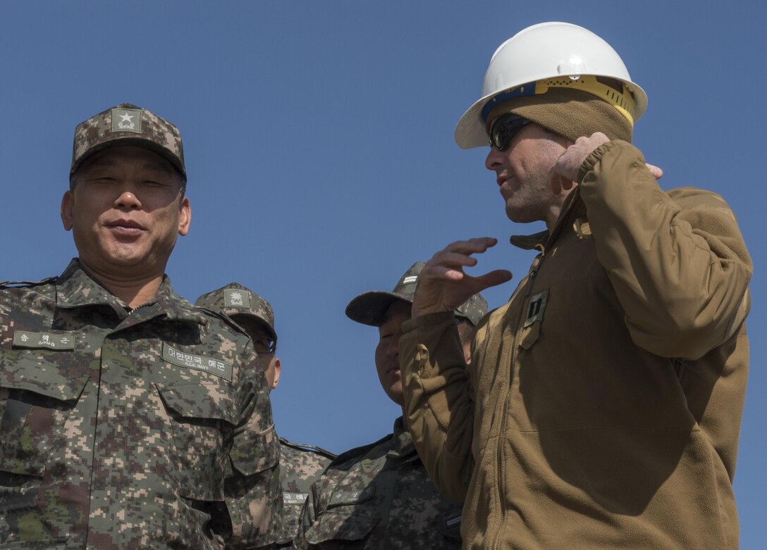 U.S. Navy Lt. Josh Baker, right, speaks with South Korean Rear Adm. Song Taek-keun, commander of Jinhae Naval Base, at the construction site of a simulated expeditionary wharf during Exercise Foal Eagle 2016 at Chinhae, South Korea, March 10, 2016. Baker is executive officer of Underwater Construction Team 2. Navy photo by Petty Officer 1st Class Charles E. White