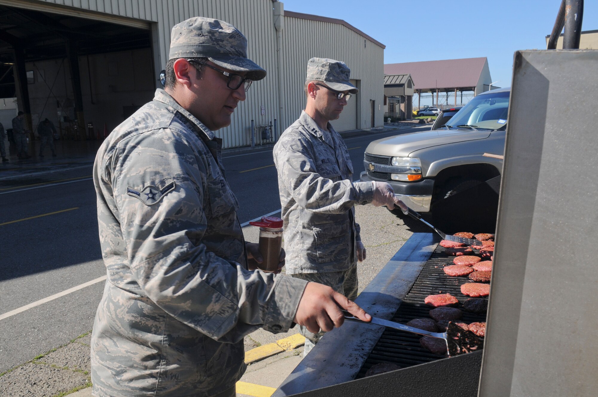 Airman Armado Esparza, and Chaplain (Capt.) Jeromy Wells, barbeque at Beale Air Force Base, California, Mar. 17, 2016. The Beale Chaplain Corps Team held the inaugural “Airman 2 Airman” Prayer Lunch. The grill team cooked more than 300 burgers for the event. (U.S. Air Force photo by Senior Airman Michael Hunsaker)