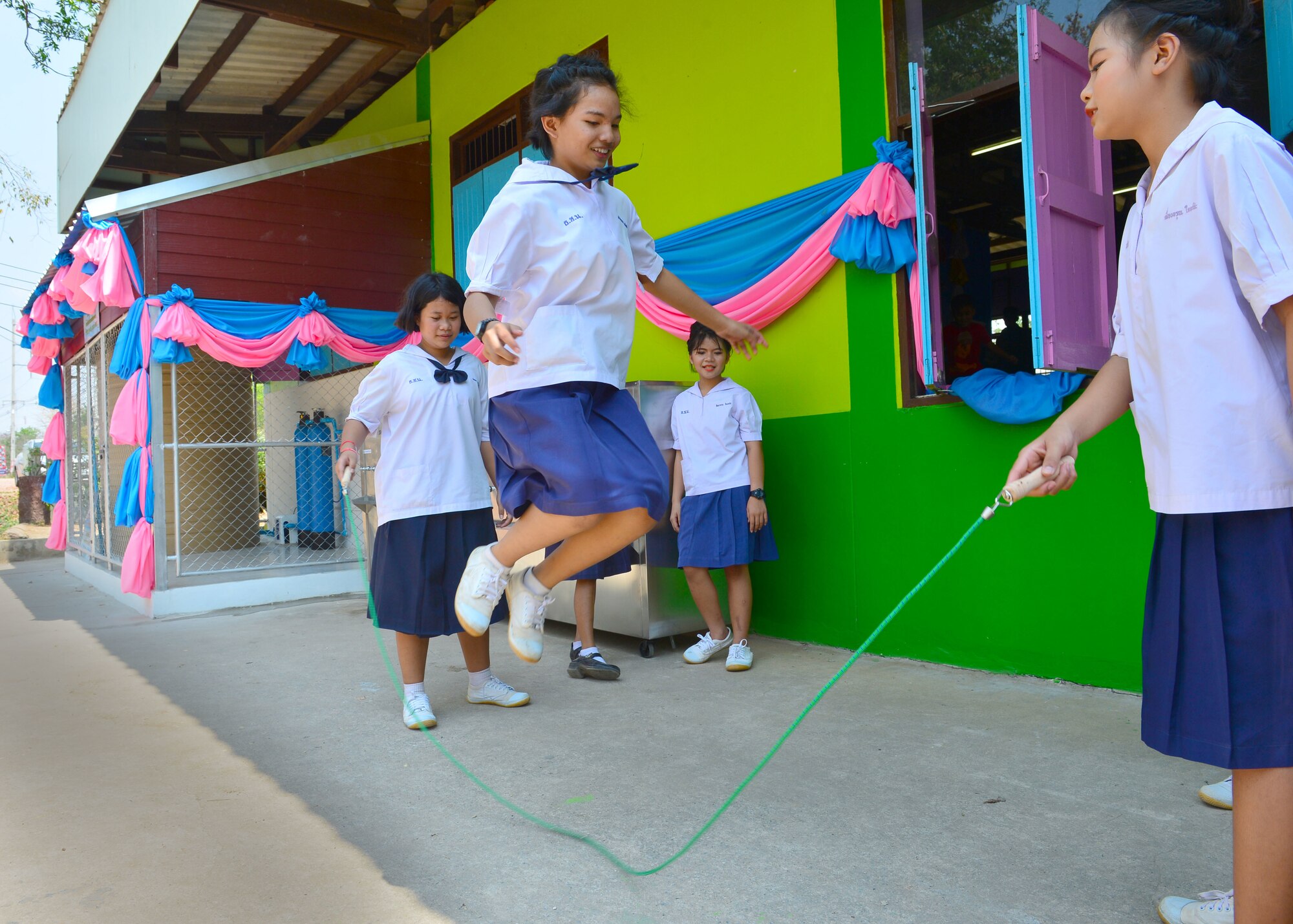 Students play with new sports equipment in front of a new water filtration system donated by  civilians and military members from the Royal Thai Air Force, the Republic of Singapore Air Force, and the U.S. Air Force during the Exercise Cope Tiger 16 combined civic action engagement at Thong Chai Wittaya Primary School, Korat, Thailand, March 15, 2016. The combined civic action engagement provides an outlet for the countries participating in Cope Tiger to give back to the community surrounding Korat Royal Thai Air Force Base. Exercise Cope Tiger is multilateral field training exercise and includes more than 1,200 personnel from the United States, Thailand and Singapore. The purpose of this exercise is to improve readiness and interoperability between three countries and continue the growth of strong relationships within the Asia-Pacific Region. (U.S. Air Force Photo by Tech Sgt. Aaron Oelrich/Released)