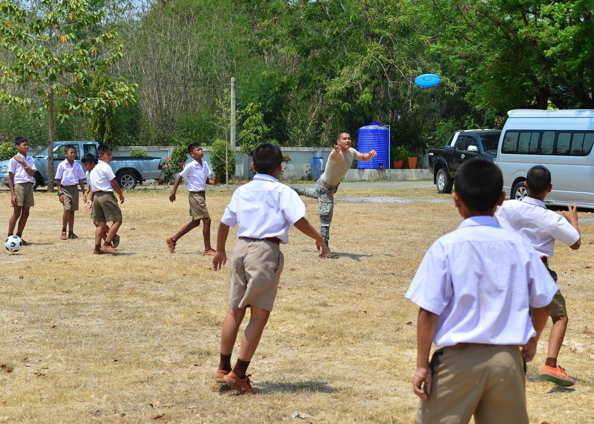 Airman 1st Class Thai Le, from the 67th Aircraft Maintenance Unit, Kadena Air Base, Japan, plays with students during the Exercise Cope Tiger 16 combined civic action engagement at Thong Chai Wittaya Primary School, Korat, Thailand, March 15, 2016. The combined civic action engagement provides an outlet for the countries participating in Cope Tiger to give back to the community surrounding Korat Royal Thai Air Force Base. Exercise Cope Tiger is multilateral field training exercise and includes more than 1,200 personnel from the United States, Thailand and Singapore. The purpose of this exercise is to improve readiness and interoperability between three countries and continue the growth of strong relationships within the Asia-Pacific Region. (U.S. Air Force Photo by Tech Sgt. Aaron Oelrich/Released)