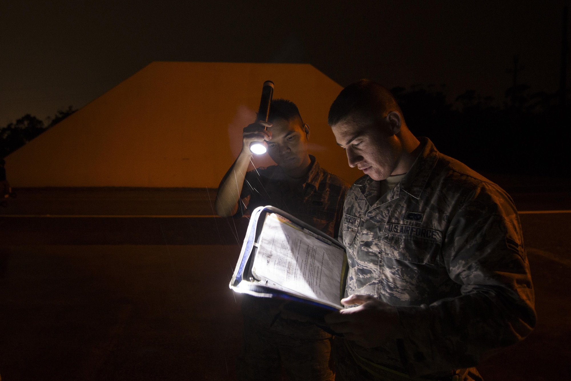 Airman 1st Class Troy Stephenson, 18th Munitions Squadron, reads over safety procedures before preparing to move munitions during a no-notice exercise March 17, 2016, at Kadena Air Base, Japan. 18th MUNS Airmen train like they would fight night or day. (U.S. Air Force photo by Senior Airman Omari Bernard/Released)