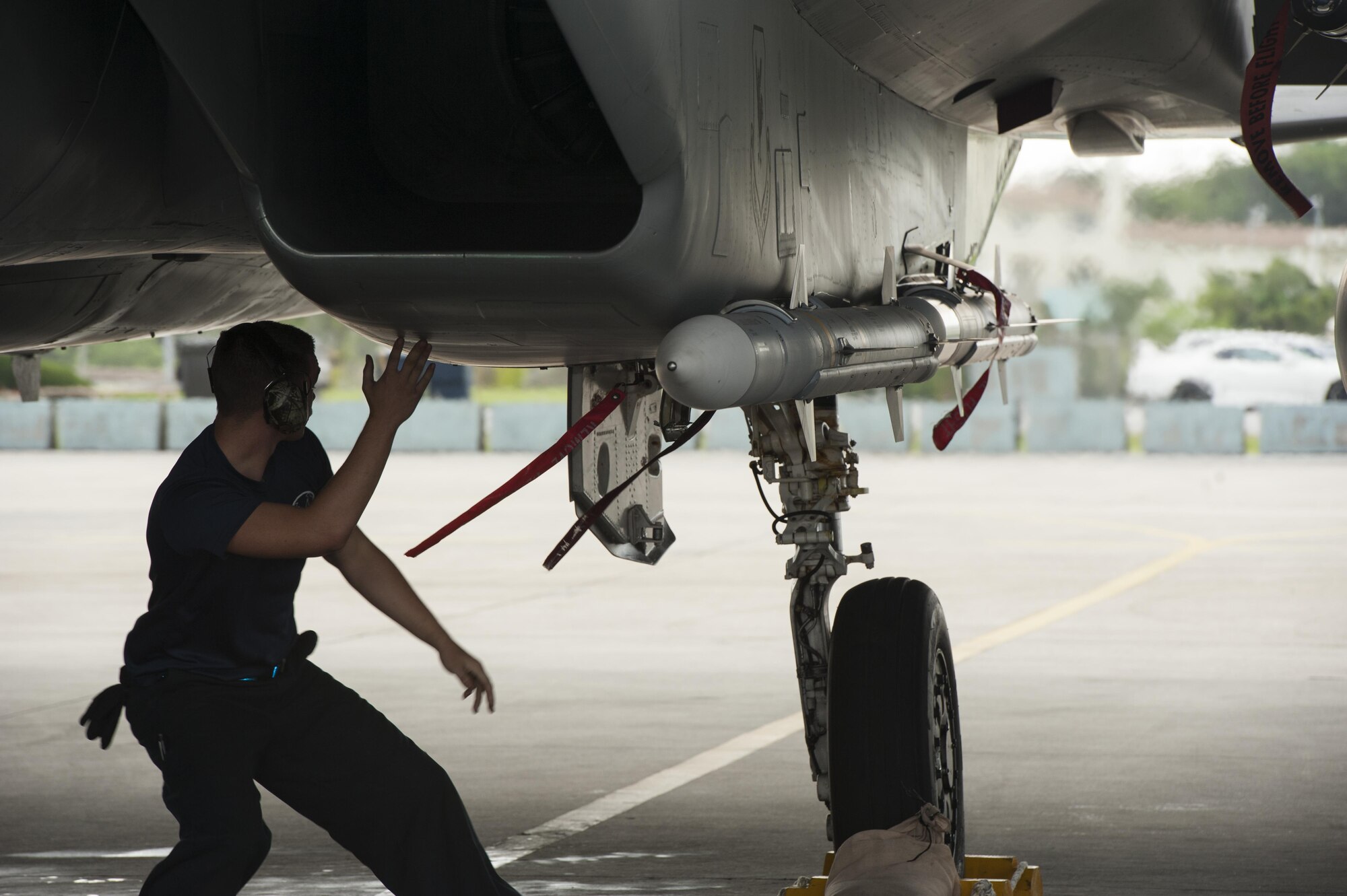 U.S. Air Force Senior Airman Zachary Sutphin, 44th Fighter Squadron crew chief, disengages safety pins during a pre-flight check March 18, 2016, at Kadena Air Base, Japan. It is with the combined efforts of maintainers and pilots that Kadena can provide regional security throughout the Indo-Asia-Pacific region. (U.S. Air Force photo by Airman 1st Class Lynette M. Rolen)