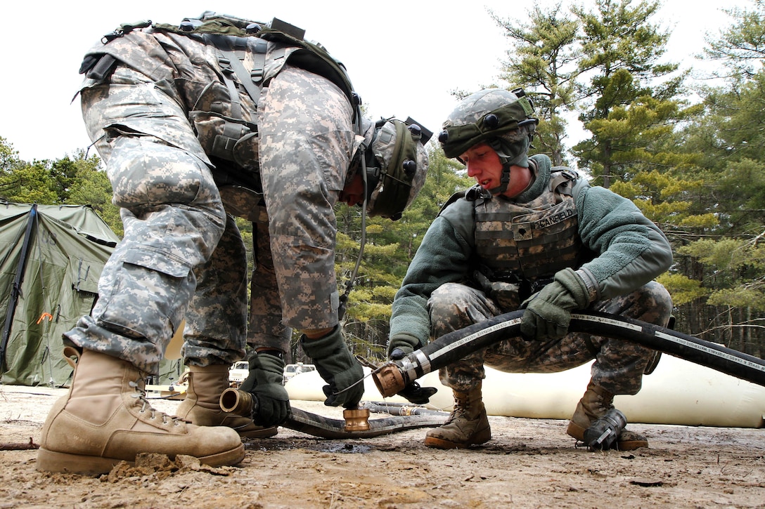 Army Spcs. Orlando Espinoza, left, and Ryan Canfield establish connections between potable water holding bags at the Brindle Lake training area on Joint Base McGuire-Dix-Lakehurst, N.J., March 6, 2016. Espinoza and Canfield are assigned to the 301st Quartermaster Company. Army photo by Spc. Michael McDevitt