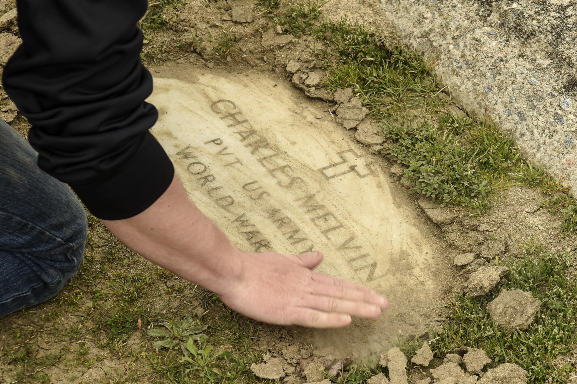 Senior Airman Daniel Shores, 4th Security Forces Squadron assistant NCO in charge of the armory, cleans the headstone of Charles Melvin, a World War II veteran, March 12, 2016, in Goldsboro, North Carolina. Airman Leadership School class 16-C identified more than 350 veterans buried at Elmwood Cemetery to honor at future events and ceremonies.  (U.S. Air Force photo/Airman Shawna L. Keyes)