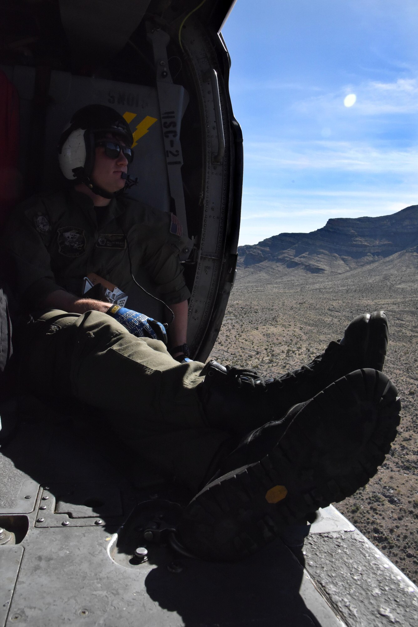 U.S. Navy AWS2 Dillon Wilson, Helicopter Sea Combat Squadron 21 Naval helicopter aircrewman, scans scenery while communicating with other aircrewman during a joint-service personnel rescue mission March 2, 2016, near Nellis Air Force Base, Nevada. Wilson and other aircrewmen participated in Red Flag 16-2 to enhance joint-service and allied mission effectiveness for worldwide operations. (U.S. Air Force photo/Staff Sgt. Chuck Broadway)