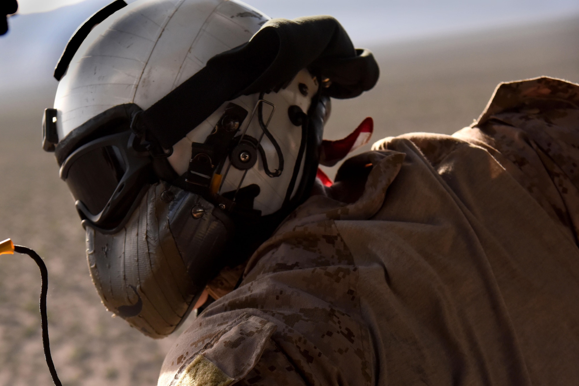 U.S. Navy AWS2 Benjamin McCracken, Helicopter Sea Combat Squadron 21 Naval helicopter aircrewman searches for a downed pilot during a joint-service personnel rescue training mission March 2, 2016, near Nellis Air Force Base, Nevada. As part of Red Flag 16-2, Navy combat search and rescue teams worked alongside U.S. Air Force survival teams to enhance training and joint-operations capabilities. (U.S. Air Force photo/Staff Sgt. Chuck Broadway)