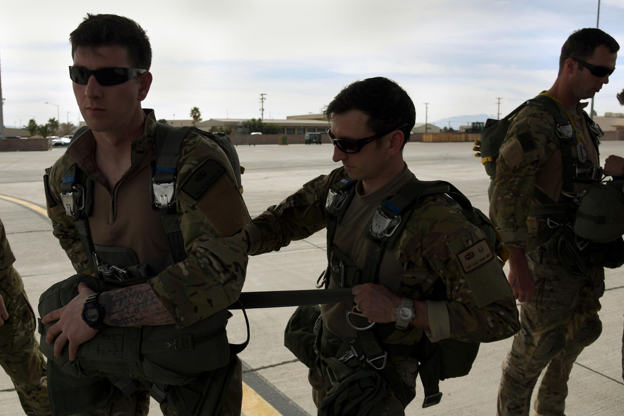 U.S. Air Force Tech. Sgt. Josh Embry, a 36th Rescue Squadron survival, evasion, resistance and escape specialist, assists Senior Airman Alan Hamilton 22nd Training Squadron SERE specialist with his harness prior to boarding a C-130 Hercules March 3, 2016, at Nellis Air Force Base, Nevada. SERE specialists from several bases across the Air Force attended Red Flag 16-2 to perform a multitude of missions during the two-week exercise. (U.S. Air Force photo/Staff Sgt. Chuck Broadway)