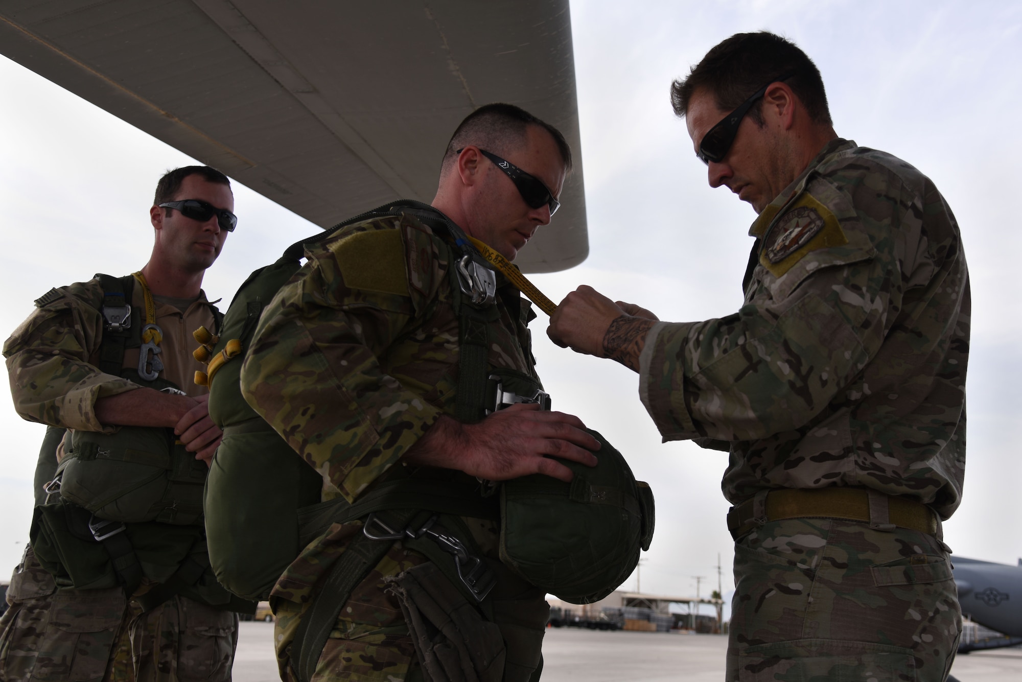 U.S. Air Force Tech. Sgt. Brandon Klein, 36th Rescue Squadron survival, evasion, resistance and escape specialist, adjusts the parachute cable of Staff Sgt. James Long, 1st Operations Support Squadron SERE specialist, prior to boarding a C-130 Hercules March 3, 2016, during Red Flag 16-2 at Nellis Air Force Base, Nevada. Specialists perform buddy checks on each team member prior to beginning a jump mission to ensure safety and integrity of equipment. (U.S. Air Force photo/Staff Sgt. Chuck Broadway)