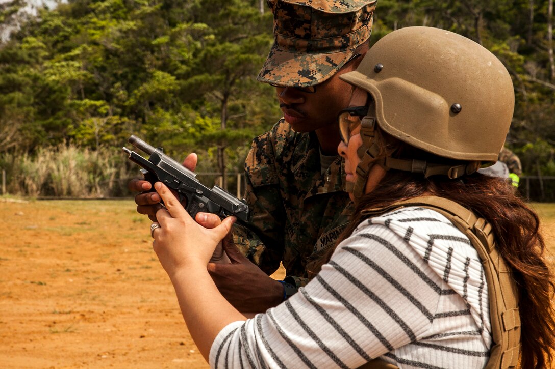 Yukiko Roman shoots an M9 service pistol at Camp Schwab, Okinawa, Japan, March 18, 2016. Roman was able to experience dynamic facets of life in the Marine Corps. This included an Amphibious Assault Vehicle raid, firing the M16-A4 service rifle, firing the M240B medium machine gun, wearing flak jackets with Kevlar helmets and eating packaged military rations. Roman is an Okinawa resident and married to a Marine with Combat Assault Battalion, 3rd Marine Division, III Marine Expeditionary Force. (U.S. Marine Corps photo by Pfc. Nelson B. Duenas /Released)