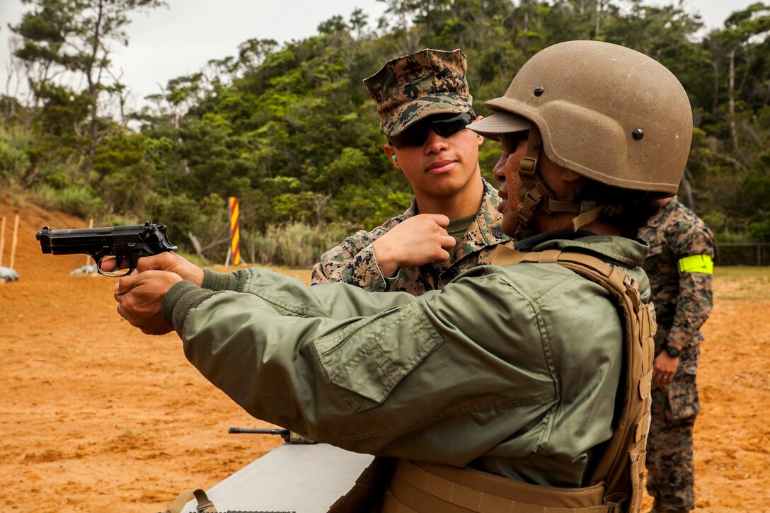David Lucar shoots an M9 service pistol at Camp Schwab, Okinawa, Japan March 18, 2016. Lucar was able to experience dynamic facets of life in the Marine Corps. This included an Amphibious Assault Vehicle raid, firing the M16-A4 service rifle, firing the M240B medium machine gun, wearing flak jackets with Kevlar helmets and eating packaged military rations. Lucar is an Okinawa resident and the uncle of a Marine with Combat Assault Battalion, 3rd Marine Division, III Marine Expeditionary Force. (U.S. Marine Corps photo by Pfc. Nelson B. Duenas /Released)