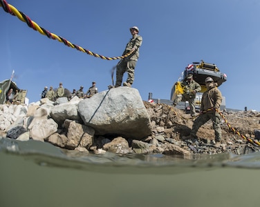 U.S. Navy Petty Officer 2nd Class Jesus Saucedo Gomez, right, and Petty Officer 3rd Class Ryan Marsi monitor U.S. and South Korean divers as they work on a simulated expeditionary wharf during Exercise Foal Eagle 2016 at Chinhae, South Korea, March 10, 2016. Gomez is a builder and Marsi is an information systems technician assigned to Underwater Construction Team 2. Navy photo by Petty Officer 1st Class Charles E. White