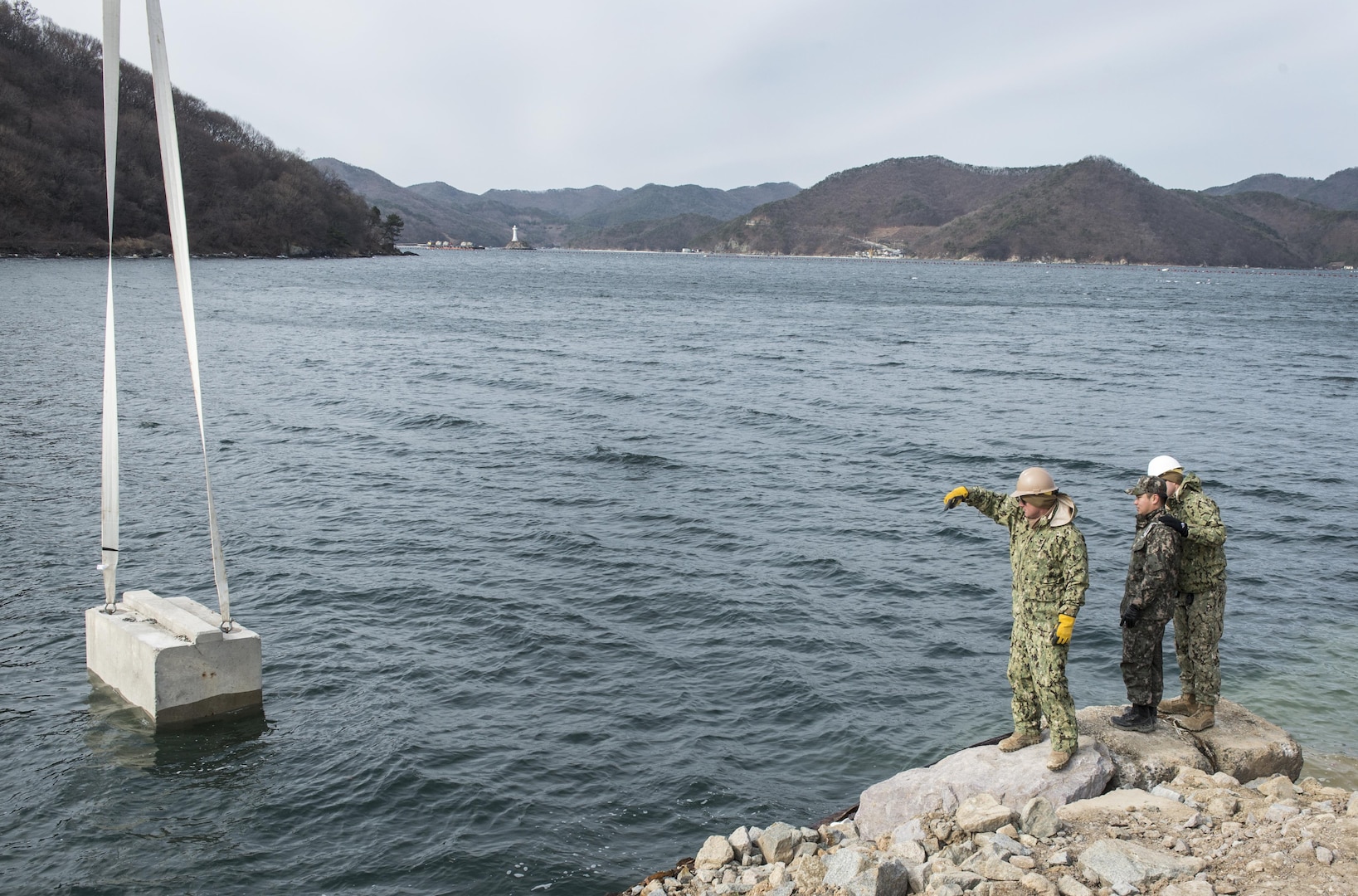 U.S. Navy Petty Officer 1st Class Jesse Hamblin, left, directs the movement of a cement block into the water during the construction of a simulated expeditionary wharf as part of Exercise Foal Eagle 2016 at Chinhae, South Korea, March 10, 2016. Hamblin is a steelworker assigned to Underwater Construction Team 2. Foal Eagle is an annual, bilateral training exercise designed to enhance the readiness of U.S. and South Korean forces, and their ability to work together during a crisis. Navy photo by Petty Officer 1st Class Charles E. White