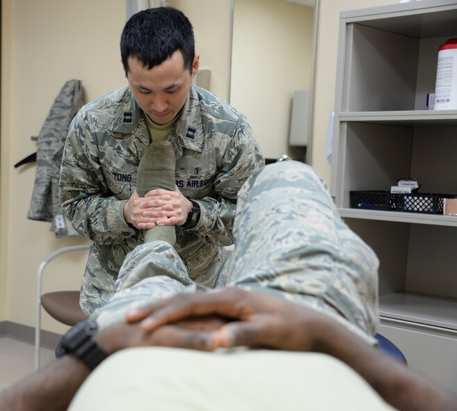 Capt. Grant Tong, 60th MDOS physical therapist, performs a talocrul manipulation for an ankle sprain March 16 at Travis Air Force Base, California. Injuries that have happened within the last 14 days can be reported directly to the physical therapy and occupational therapy departments at David Grant USAF Medical Center to receive direct access to therapist without receiving a referral from a primary care manager. (U.S. Air Force photo by Senior Airman Amber Carter)