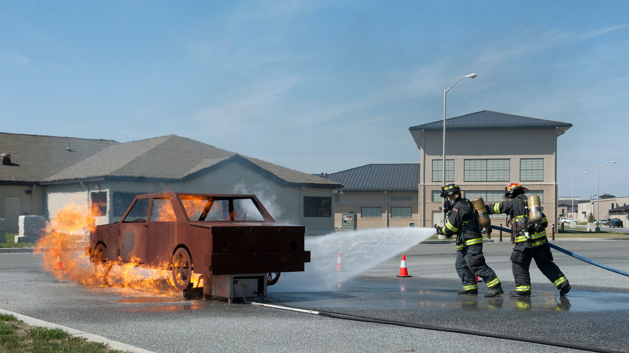 Senior Airman Chris Ladue and Tech Sgt. Scott Morisette, 436th Civil Engineer Squadron fire fighters, take part in a demonstration by putting out an automobile fire while Col. Michael Grismer, 436th Airlift Wing commander, visits the fire department March 16, 2016, on Dover Air Force Base, Del. The demonstration was used to give Grismer a better understanding of the fire department’s readiness and capabilities. (U.S. Air Force photo/Senior Airman Zachary Cacicia)