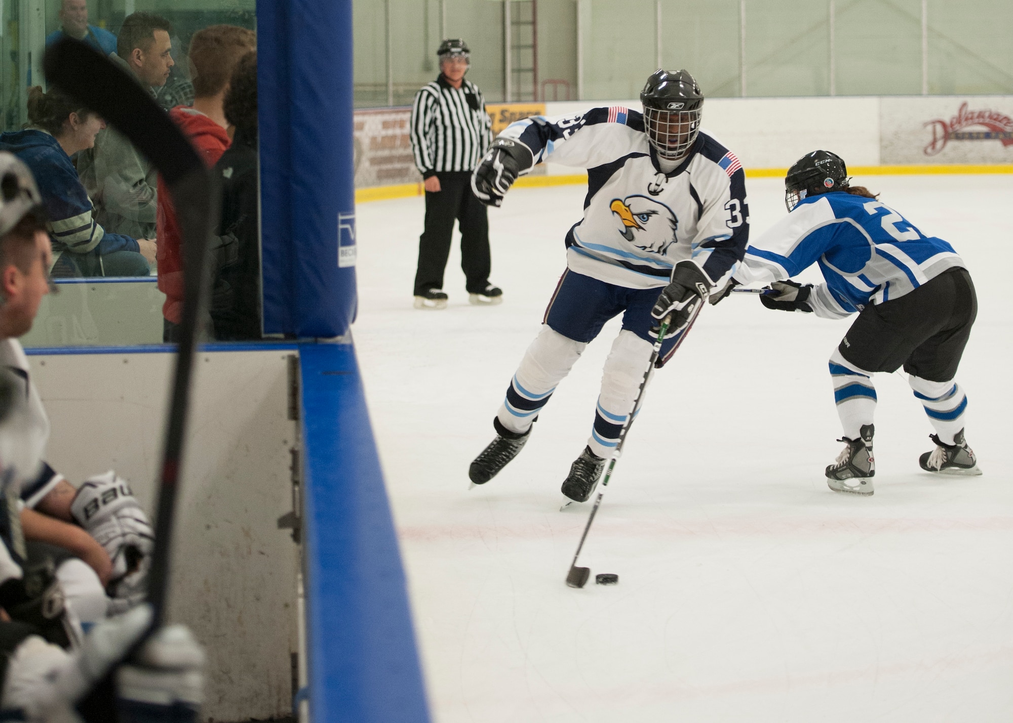 Joseph Beard, Dover Eagles forward, skates past a Fraternal Order of Police Lodge 15 defensemen during a charity hockey game March 13, 2016, at the Centre Ice Rink in Harrington, Del. This charity game raised money for the Concerns of Police Survivors (COPS) charity. (U.S. Air Force photo/Senior Airman Zachary Cacicia)